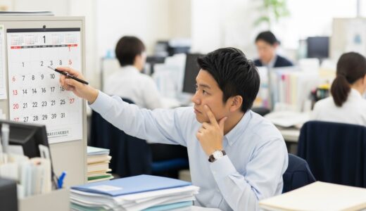 オフィスの壁に貼られたカレンダーを見つめながら、有給申請を迷っている様子の30代男性会社員。デスクには書類が積まれ、周囲には忙しそうに働く同僚の姿